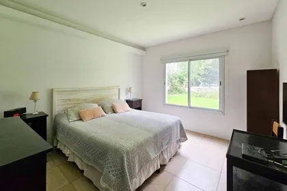 Dormitorio moderno con cama king, luz cálida y ventana grande — proyecto San Matías, por GeN Arquitectura, en Ingeniero Maschwitz